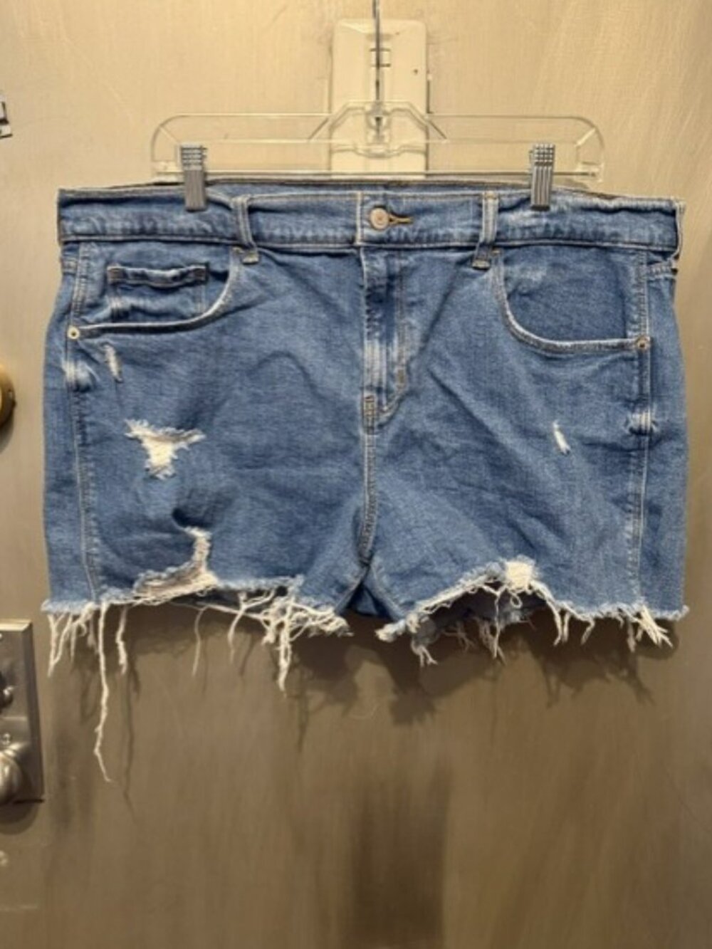 Distressed boyfriend denim cut-off shorts featuring a raw, frayed hem